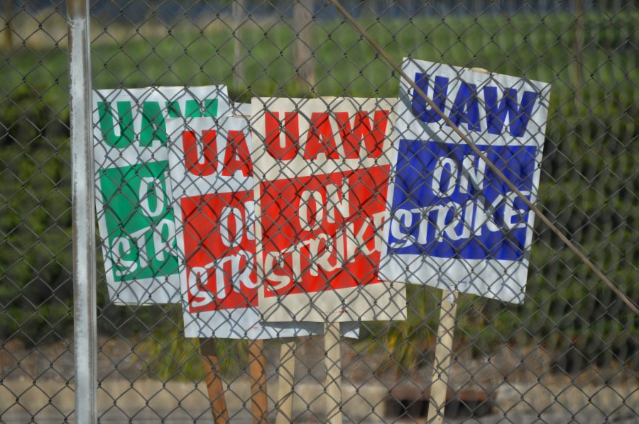 Several UAW on strike signs.