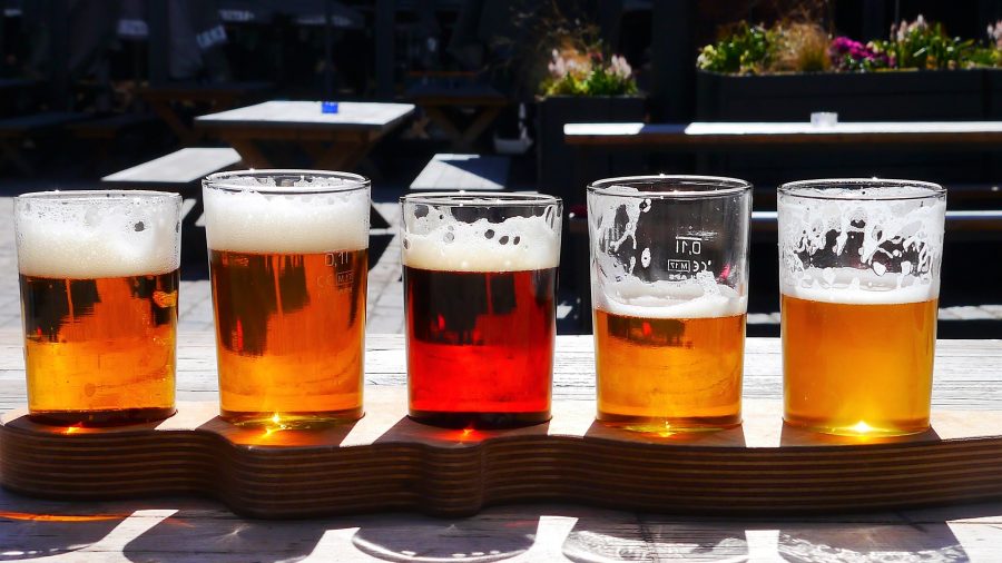 A flight of beer ranging in color and liquid levels.