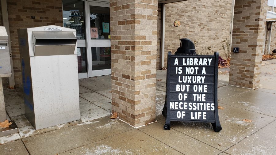Sign outside a library reads, "A library is not a luxury, but one of the necessities of life."