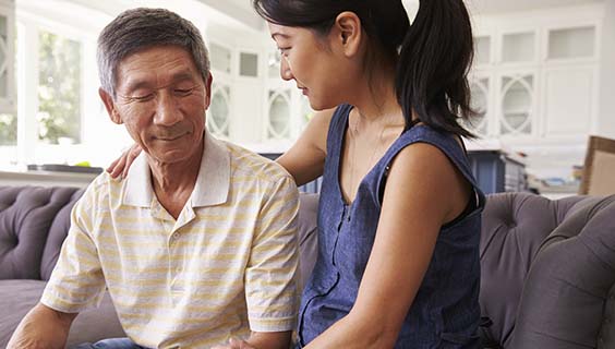 Adult Daughter Talking To Depressed Father At Home